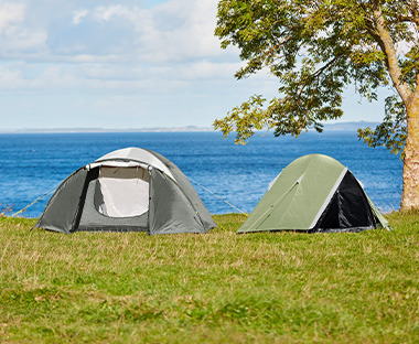 Twee tenten in het gras aan het water