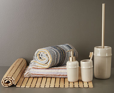 Badmat van bamboe met handdoeken, tandenborstelhouder en wc-borstelhouder