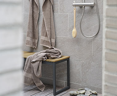 Bruine handdoeken in badkamer en op bankje