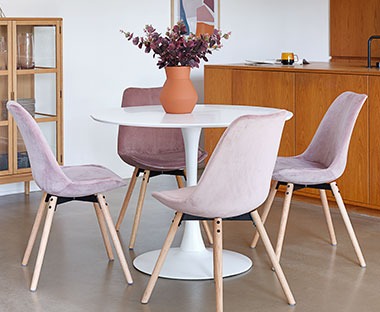 Fluweel roze stoel met eiken poten rond een witte tafel