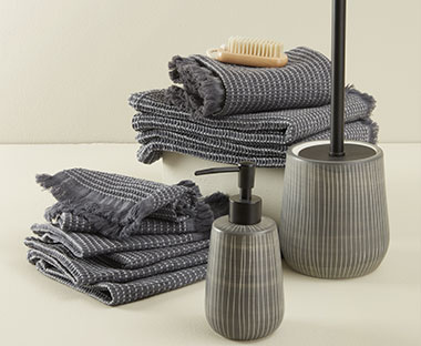 Donker grijze handdoeken, wc borstel en zeepdispenser