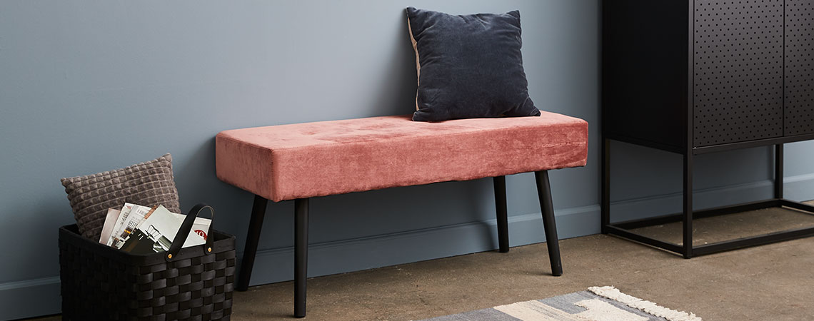 Bench in pink velour placed against the wall