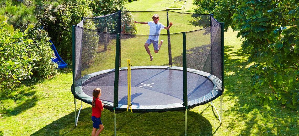 Kinderen spelen op een grote trampoline in de tuin 