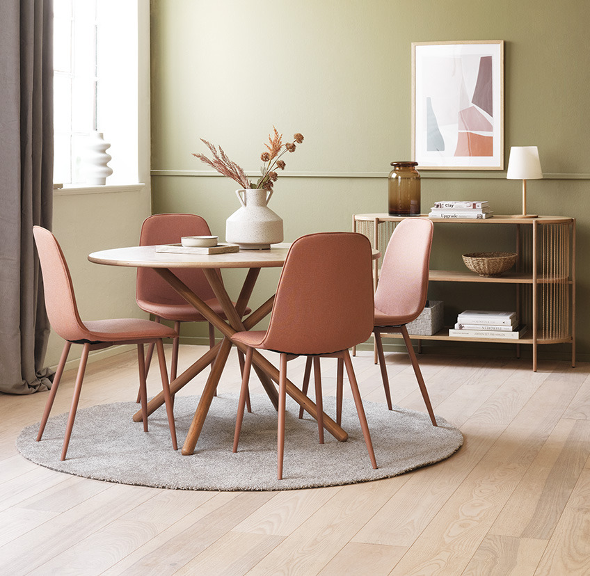 Perzik eetkamerstoelen rond ronde eettafel in woonkamer  