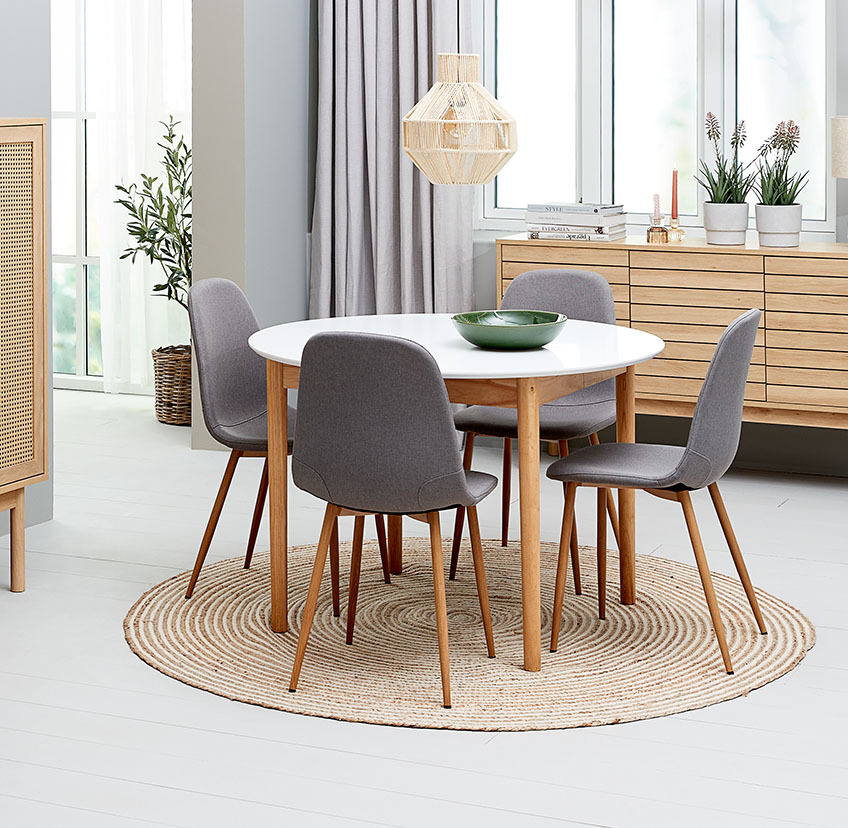 Grey dining room chair with steel legs and round dining table in white and oak
