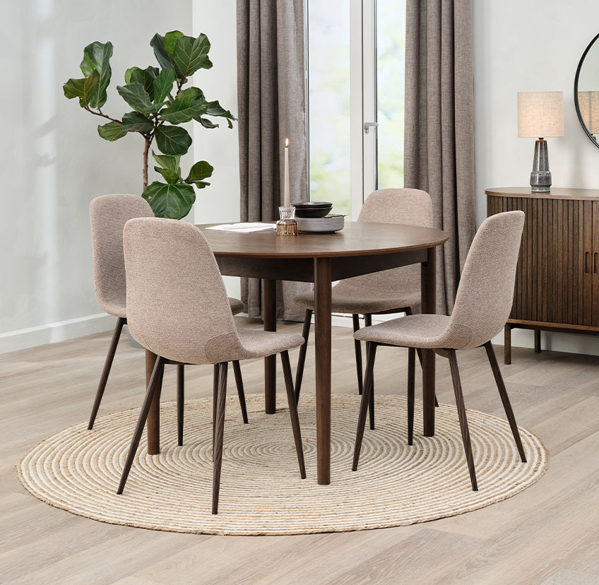 Beige dining room chair with dark steel legs and round dining table in dark oak
