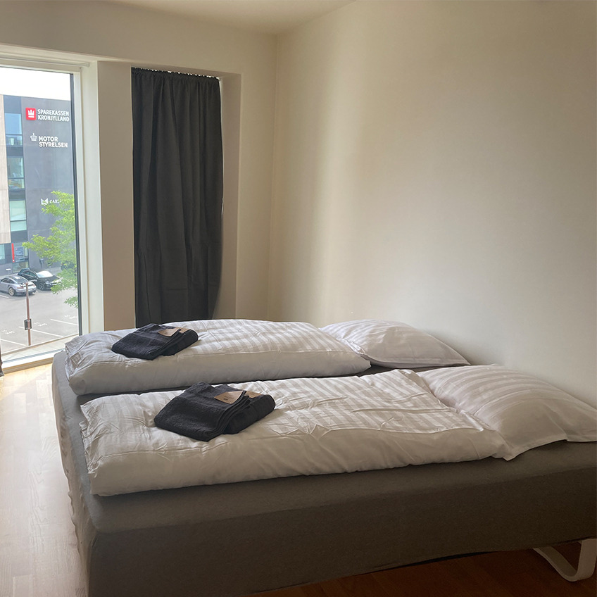 Gemeubileerde slaapkamer met bedden en gordijnen