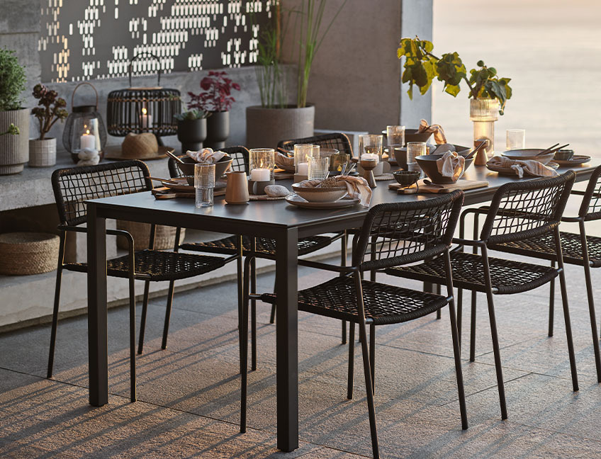 Tuintafel en -stoelen voor diner op terras bij zonsondergang