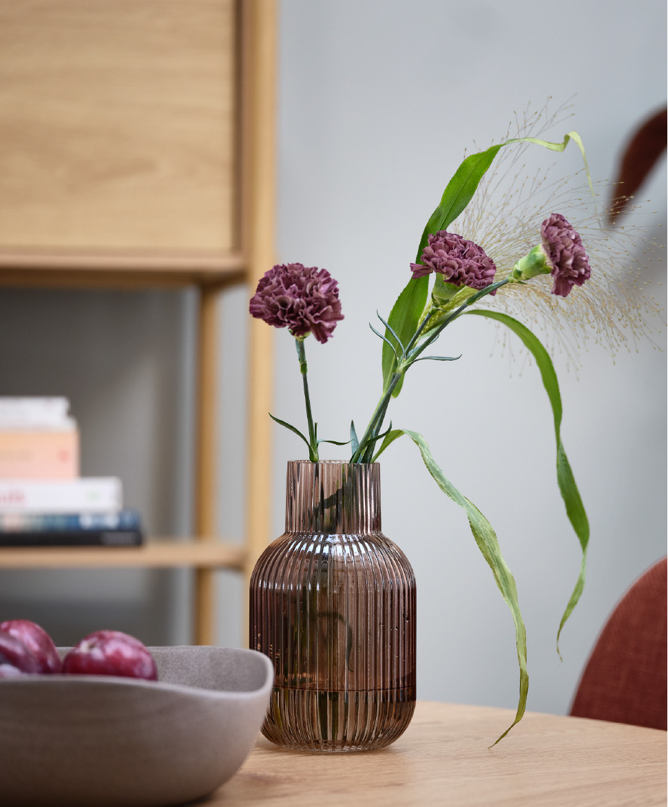 Bruine vaas op een tafel met een kunstbloem