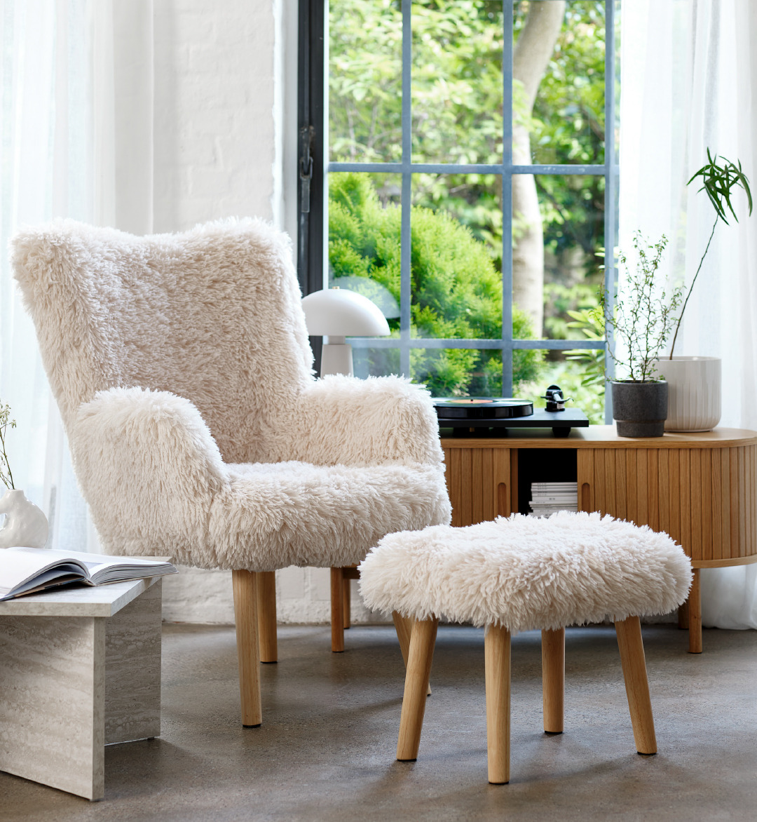 Witte fauteuil met een poef