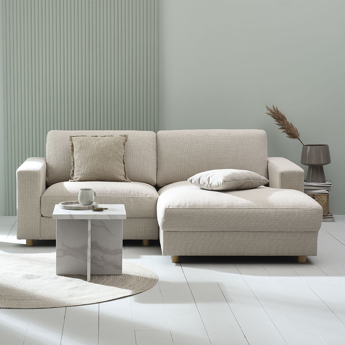 Beige 2-zitsbank met chaise longue in een moderne en minimaltische woonkamer