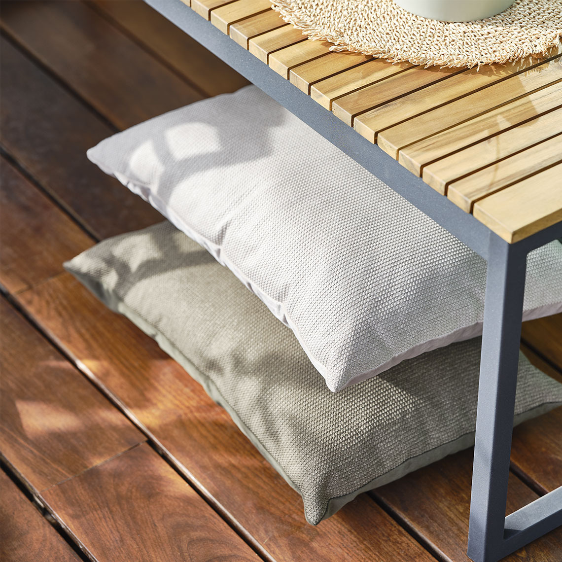 LILJE sierkussen Beige sierkussens onder een tuinbank