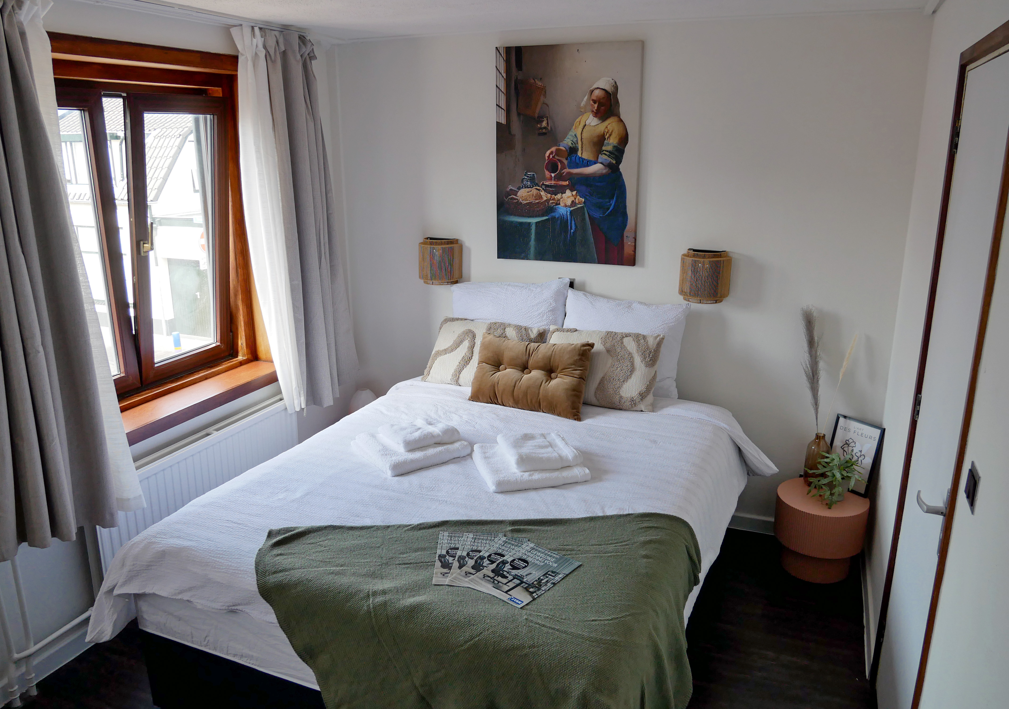 Gemeubiliseerde hotelkamer met boxspring, kussens en gordijnen
