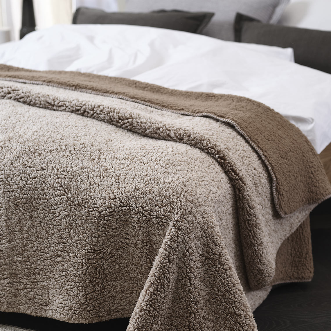 STORFRYTLE fleeceplaid Bruin fleeceplaid op een bed in een slaapkamer