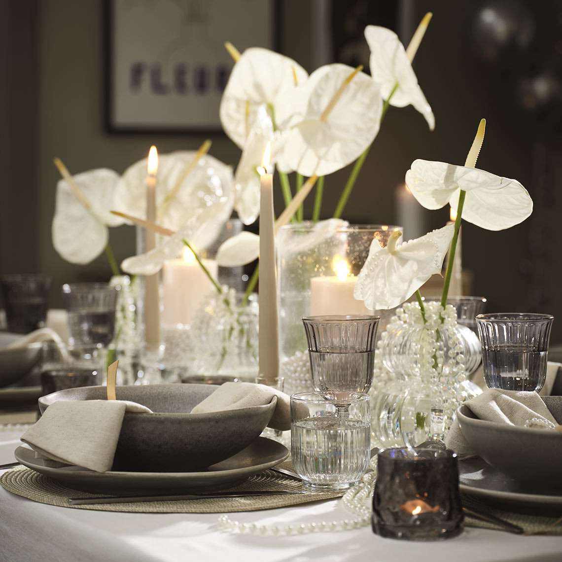 Tafel gedekt met schalen, borden, glazen en theelichthouders