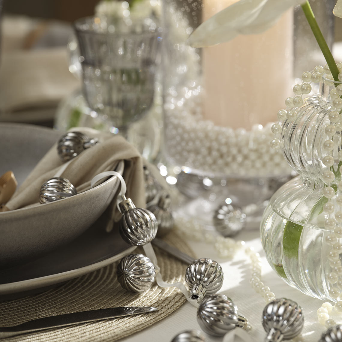 Kerstballen aan een touw op een eettafel