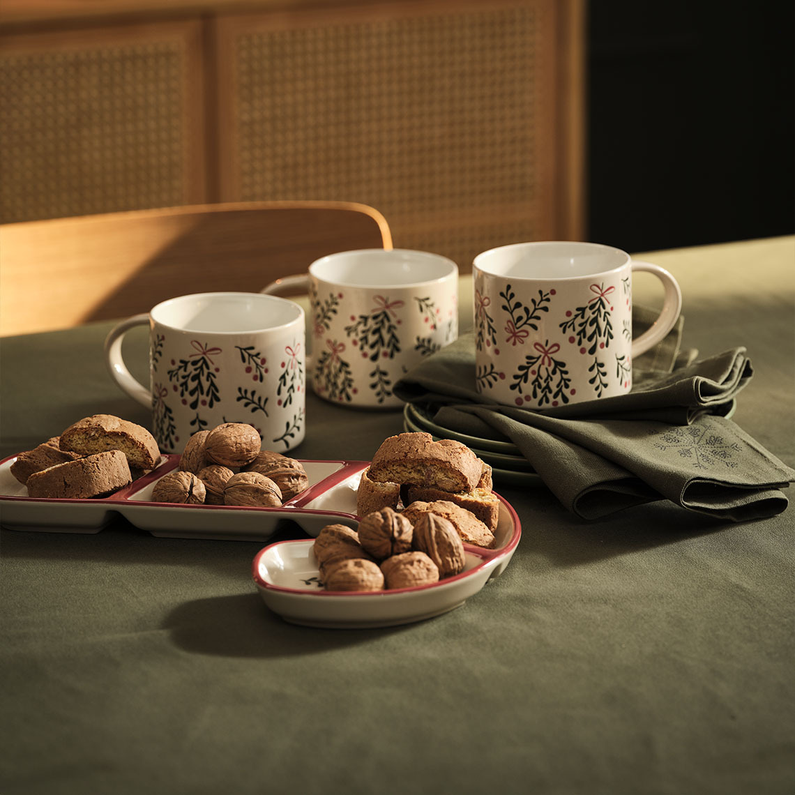 LIN mokken, LIN schaal en STJERNESTEN stoffen servetten Kerstmokken, schaal en servetten op een tafel