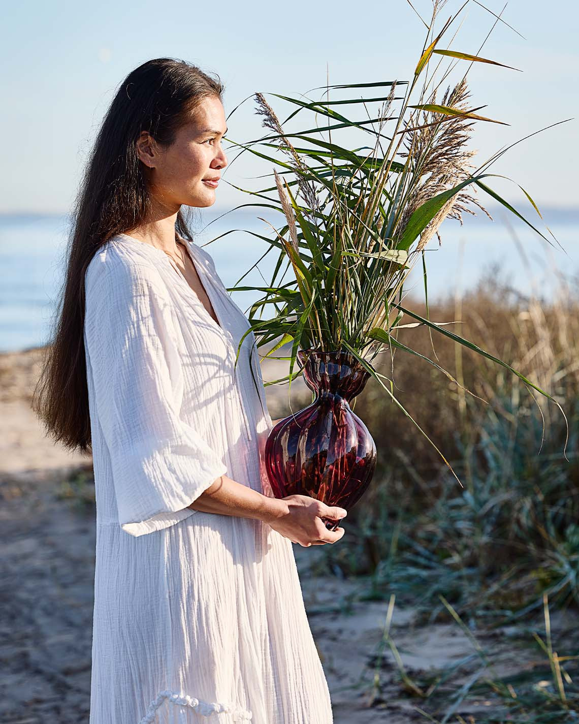 VILMER vaas Vrouw met glazen vaas met organische vorm op het strand