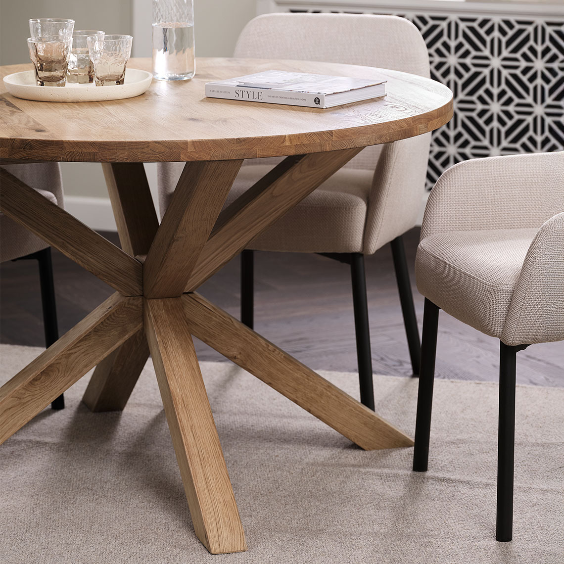 Ronde eettafel van massief FSC®-gecertificeerd eikenhout in de eetkamer met beige stoelen