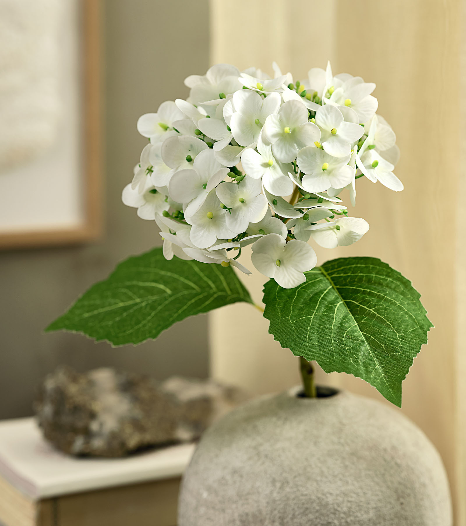 HUBERT kunst hortensia Kunstbloem, een imitatie van een witte hortensia met groene bladeren in een rustieke vaas.