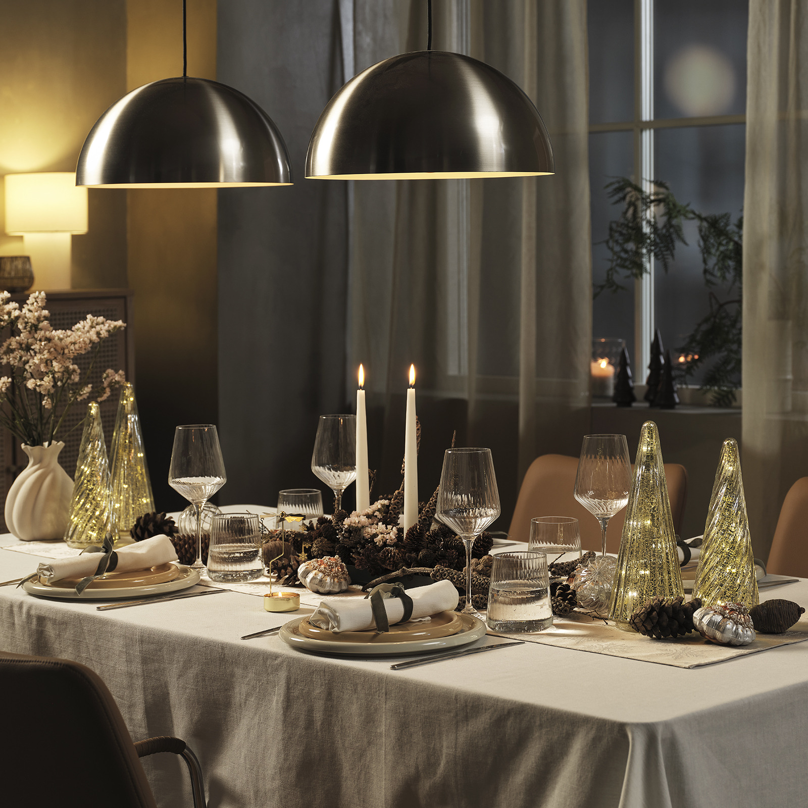 Vazen met bloemen en kerstversieringen op een gedekte kersttafel