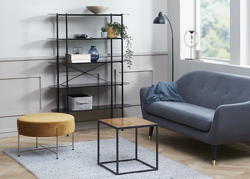 Living room with a golden pouffe, a small end table and a sofa