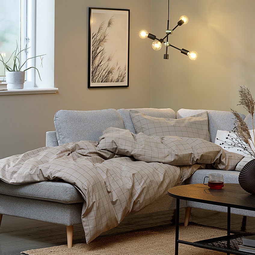 Hygge in de woonkamer met een grote hoekbank, dekens en verlichting