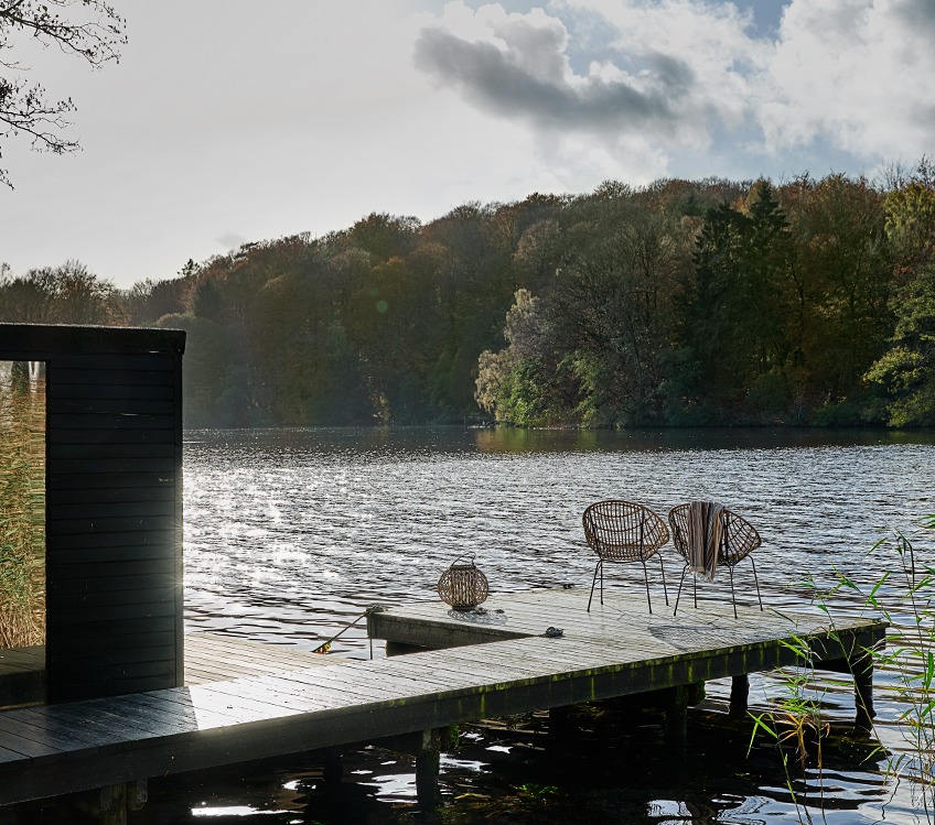 Badhanddoek hangt op een loungestoel bij een meer 