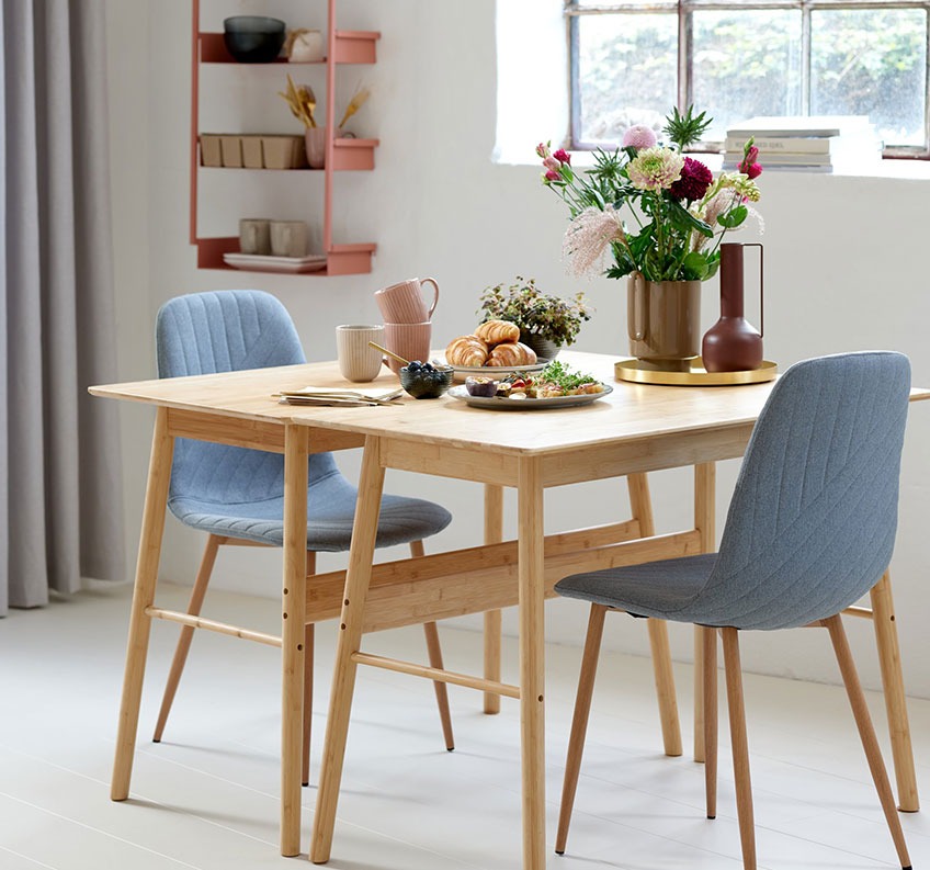 Bamboe bureaus bij elkaar gecombineerd tot een eettafel en grijze eetkamerstoelen