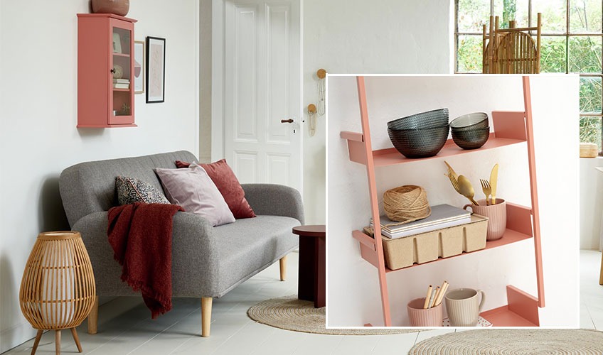 Woonkamer met rode accessoires en roze wandplank