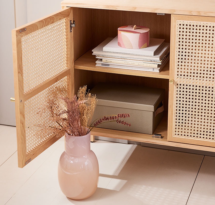 Vaas KASPER en opbergmand OLA rond in HALMSTAD dressoir Mondgeblazen vaas met een boeket kunstbloemen voor een dressoir met een open deur en een rond opbergmandje