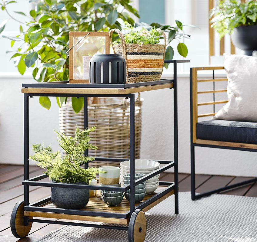 Balkon met buitenbar trolley met lantaarns, schalen en planten