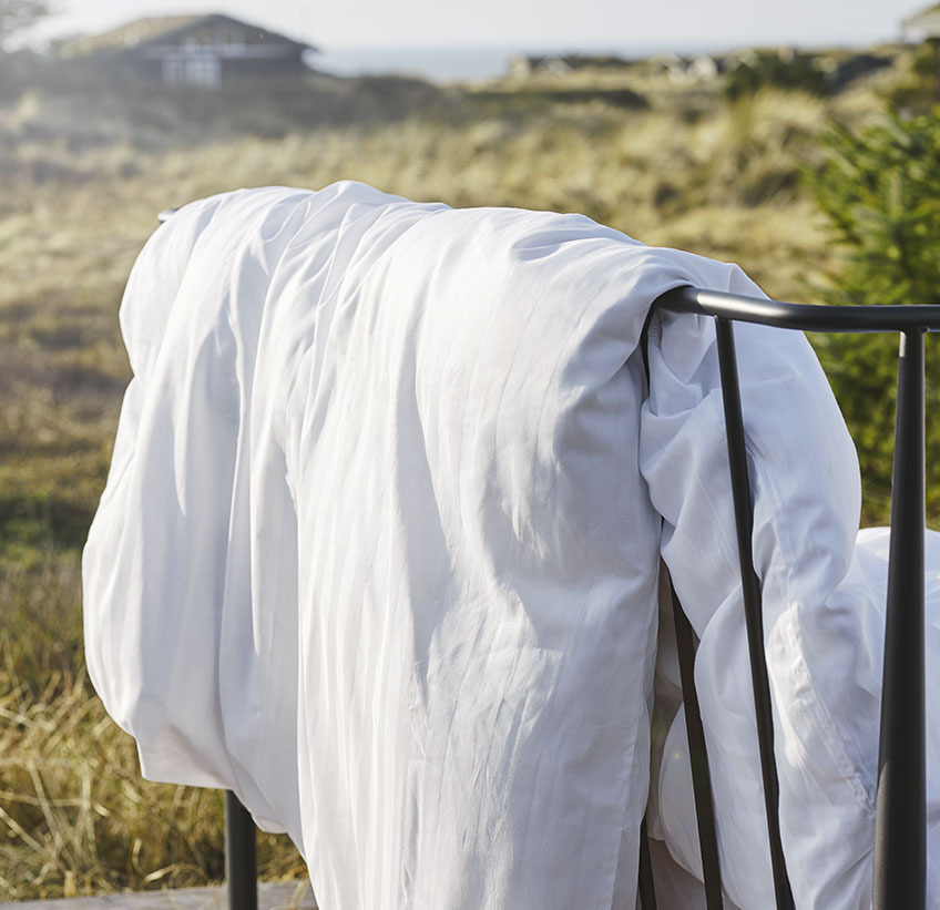 Dekbedovertrek hangend over een hek in een natuurlijke omgeving 