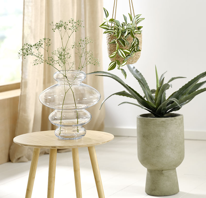 SYLVESTER vaas, hangende plantenpot STEFAN met ASGAR kunstplant en groene SOLVI planten pot met CELIUS kunstplant Glazen vaas op een bijzettafel, hangende plantenpot en groene plantenpot met kunstplanten