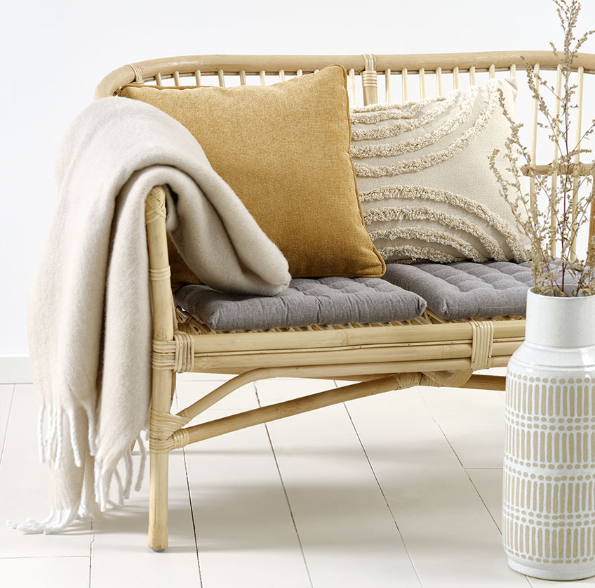 LISELEJE bank met beige GRAVMYRT sierkussen, geel HORNFIOL sierkussen en TUSENFRYD plaid Rotan bankje met beige en geel sierkussen en beige plaid