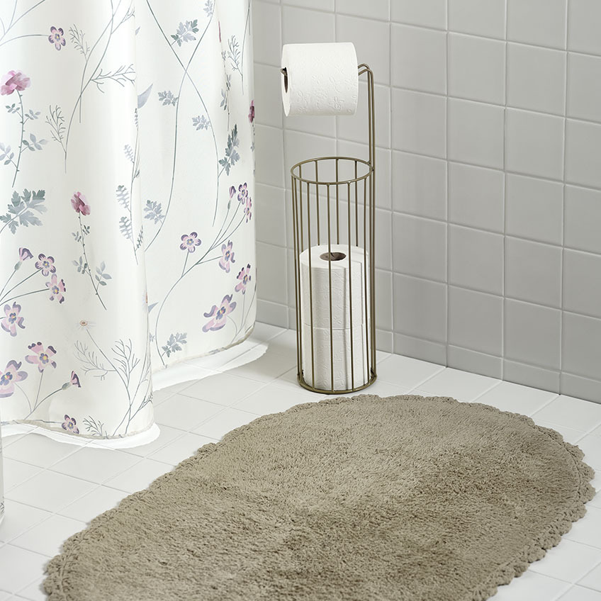 Shower curtain, bathmat and toilet roll holder in a bathroom